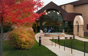 Entrance to ATSU's School of Health Management, featuring a tree out front with autumn colored leaves.