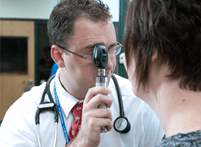 Image of ATSU student performing an eye inspection on a patient