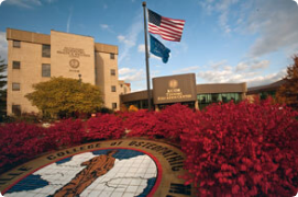 Image of KCOM campus and entrance and flags