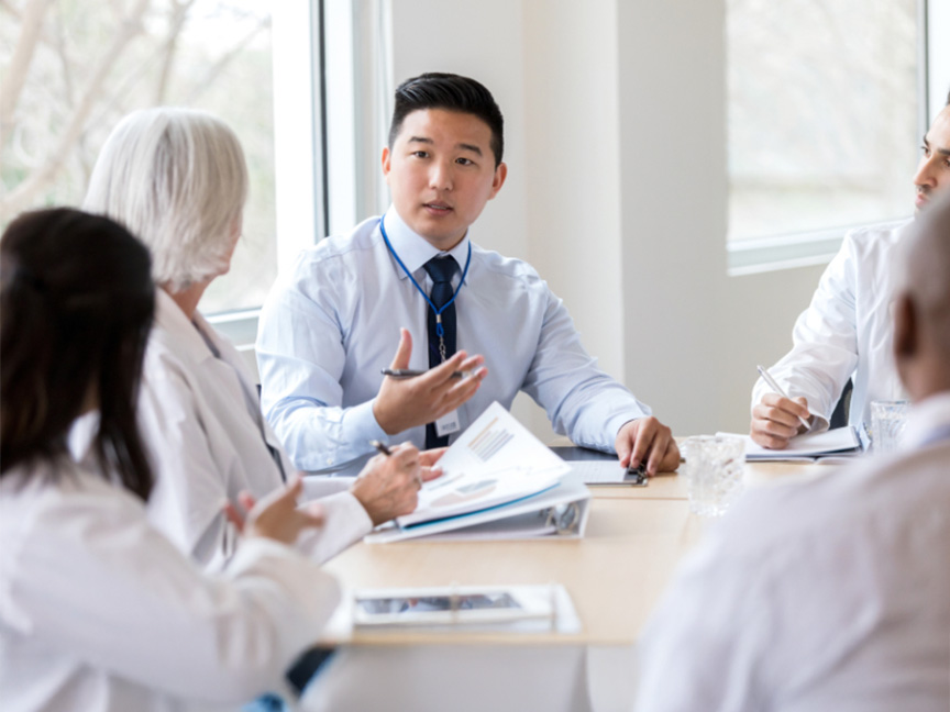 Healthcare professionals discussing together at a conference table, emphasizing collaboration and teamwork in the healthcare field.