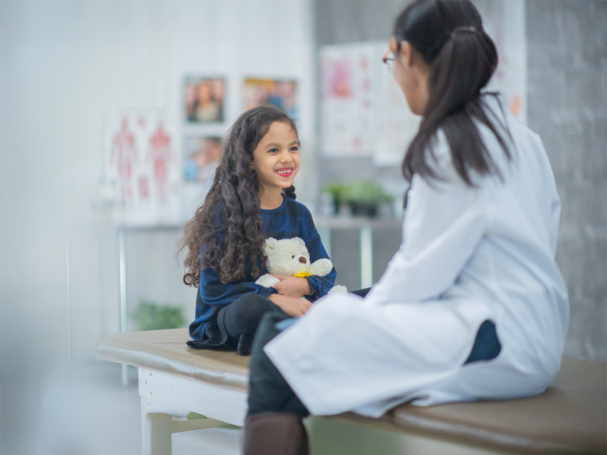 Master of Public Health student engaging with a young girl in a waiting room, showcasing compassionate and community-focused care.